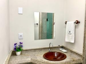 a bathroom with a sink and a mirror at SAMIR HOTEL COMFORT in Porto Velho