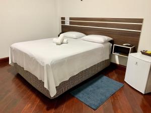 a bedroom with a large bed with a wooden headboard at SAMIR HOTEL COMFORT in Porto Velho
