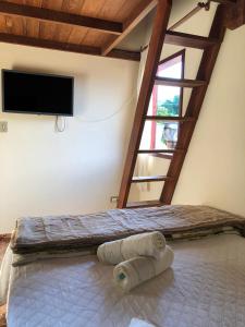 a bedroom with a large bed with a flat screen tv at casa temporada in Paraty
