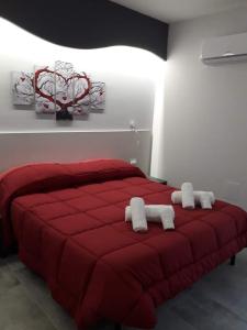 een rood bed met twee witte kussens erop bij B&B Donjon centro in Castelbuono