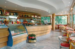 un ristorante con bancone, tavoli e sedie di Hotel Ristorante Costa a Costa Valle Imagna