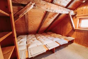 an attic room with a bed and a window at Obere Maxlraineralm in Spitzingsee
