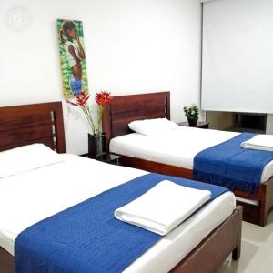 1 dormitorio con 2 camas con sábanas azules y blancas en Apartamento Morros Ultra 511 en Cartagena de Indias