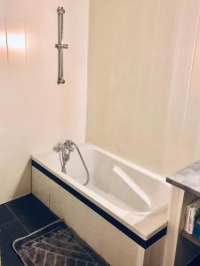 La salle de bains est pourvue d'une baignoire avec un robinet. dans l'établissement Magnifique appartement tout équipé - 6 personnes, au Puy-en-Velay