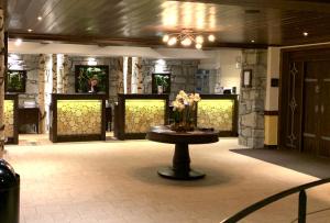 a lobby with a table with flowers on it at Arc 1950 Manoir Savoie Skis aux pieds in Bourg-Saint-Maurice +23 photos