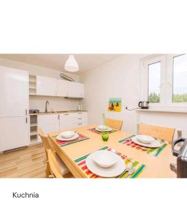 eine Küche und ein Esszimmer mit einem Tisch und Stühlen in der Unterkunft Apartament Magdalenka in Władysławowo