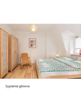 - une chambre avec un lit et une chaise dans l'établissement Apartament Magdalenka, à Władysławowo