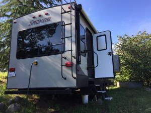 a trailer parked in the grass with its door open at Sequoia Forest Retreat in Badger