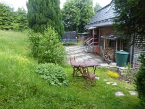 a picnic table in the grass next to a house at Haus Bergwiese - für Naturfreunde, Familien, Wanderer in Gehlberg
