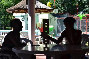 two women sitting at a table in front of a fountain at Cabañas Alpendorf in Villa General Belgrano