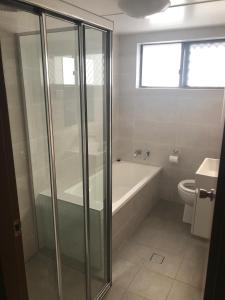a bathroom with a shower and a tub and a toilet at Breakers 3 - linen not included in Forster