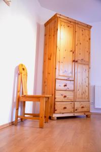 un armario de madera y una silla de madera en una habitación en Ferienwohnung Deichapfel im Alten Land (Jork), en Jork