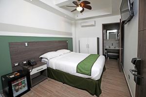1 dormitorio con 1 cama y TV en Hotel Cultura Plaza en San José