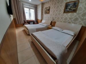 a hotel room with two beds and a television at Cát tường 2 hotel in Ho Chi Minh City