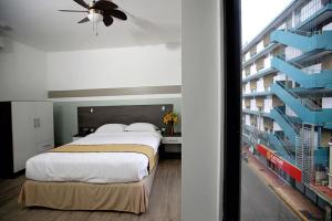 a bedroom with a large bed and a building at Hotel Cultura Plaza in San José