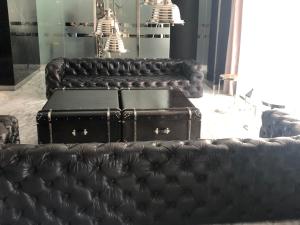 a group of black leather couches with suitcases at Lumiere Puerto Madero in Buenos Aires