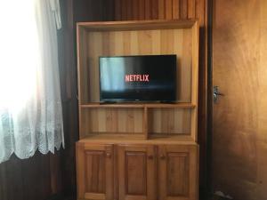 a tv in a wooden entertainment center with a tv at Casa de Ferias Dona Inês in Treze Tílias