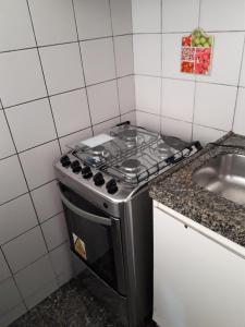 a kitchen with a stove and a sink at Apart-Hotel para 3 pessoas in Fortaleza