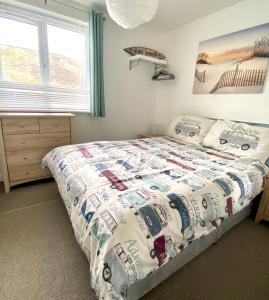 a bedroom with a bed with a quilt on it at Surf's Up in Perranporth, Cornwall Coastal Holidays in Perranporth
