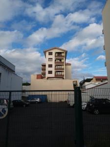 a building in a parking lot with a fence at Appartement central, wifi rapide, parking gratuit in Noumea