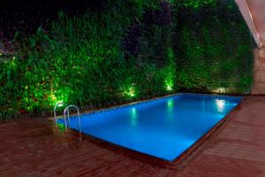 a swimming pool in a garden at night at Jambuluwuk Thamrin Hotel in Jakarta
