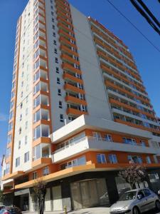 um edifício alto com um carro estacionado em frente em Depto 1 Dormitorio Centro Blanco 702 em Temuco