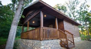 a log cabin in the woods with a large porch at Sunsettin Cabin Free Parking Onsite in Stephens Gap