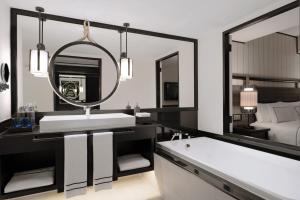 a bathroom with a sink and a tub and a mirror at Melia Koh Samui in Choeng Mon Beach