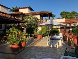 a patio with tables and chairs and an umbrella at POUSADA BLUE MOON in Búzios