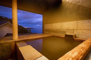 an indoor swimming pool with a view of the ocean at Isaribi (No Children) in Higashiizu
