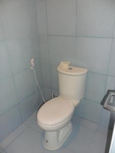 La salle de bains est pourvue de toilettes blanches et de carrelage bleu. dans l'établissement Jasmin's Room Rental, Room # 3, à Moalboal