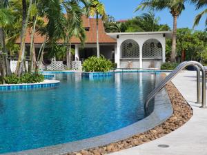 a swimming pool at a resort with palm trees at BLU PINE Villa & Pool Access - SHA Plus in Kata Beach