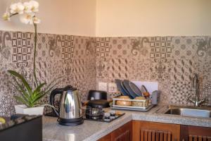 een aanrecht met een waterkoker en een wastafel bij A home, like a dream in Ubud