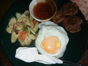zielony talerz jedzenia z jajkiem i grzybami w obiekcie ต้งโฮมหละปูน w mieście Lamphun