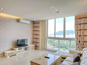 a living room with a tv and a large window at The Grand Condotel in Vung Tau
