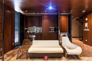 a room with a bed and two chairs and a kitchen at EXPRESSIONZ KLCC BY G Suites in Kuala Lumpur