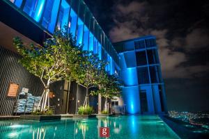 a building with a pool in front of it at night at EXPRESSIONZ KLCC BY G Suites in Kuala Lumpur