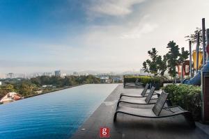 a row of benches sitting next to a swimming pool at EXPRESSIONZ KLCC BY G Suites in Kuala Lumpur