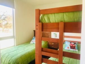 1 dormitorio con 2 literas y ventana en Cosmopolita Verde, en La Serena