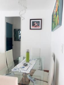 comedor con mesa de cristal y sillas blancas en Cosmopolita Verde, en La Serena