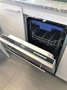 uma máquina de lavar louça com a porta aberta numa cozinha em Concón Costa de Montemar Departamento, 3 dormitorios em Concón