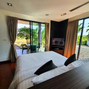 a bedroom with a bed and a view of a patio at Eden Villa Phuket in Bang Tao Beach