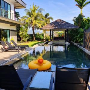 a swimming pool with a raft in the middle of a house at Eden Villa Phuket in Bang Tao Beach