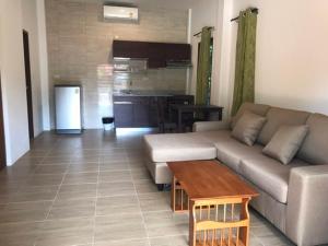 ein Wohnzimmer mit einem Sofa und einem Tisch in der Unterkunft Green Villa in Lamai