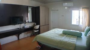 a bedroom with a bed and a desk and a television at Nasional Hotel in Gunungsitoli