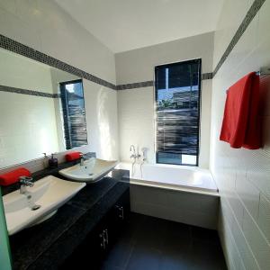 a bathroom with two sinks and a bath tub at Eden Villa Phuket in Bang Tao Beach