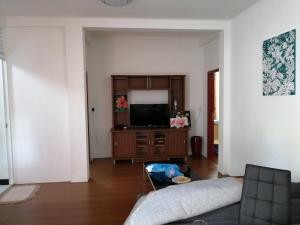 a living room with a couch and a flat screen tv at Fali Guest House in Kudahuvadhoo