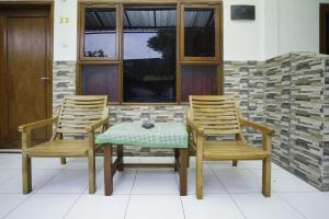 un tavolo con due sedie e un tavolo e due finestre di Hotel Tentrem Syariah a Probolinggo