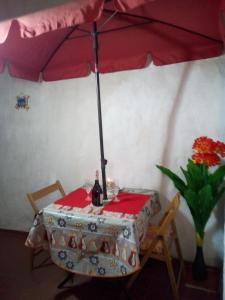 AL MARE, AL SOLE, SI', ma nella CASA DEL MINATORE في بوجيرو: طاولة عليها مظلة وزجاجة من النبيذ