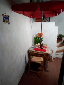 a table with a red umbrella in a room at AL MARE, AL SOLE, SI', ma nella CASA DEL MINATORE in Buggerru